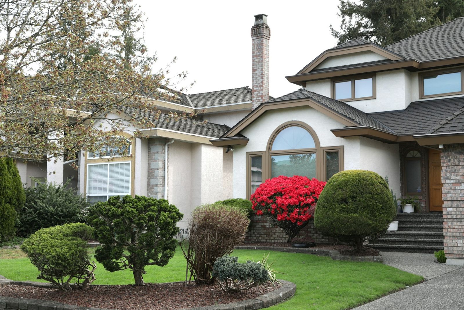 Front of a house with shaped shrubs and fresh mulch